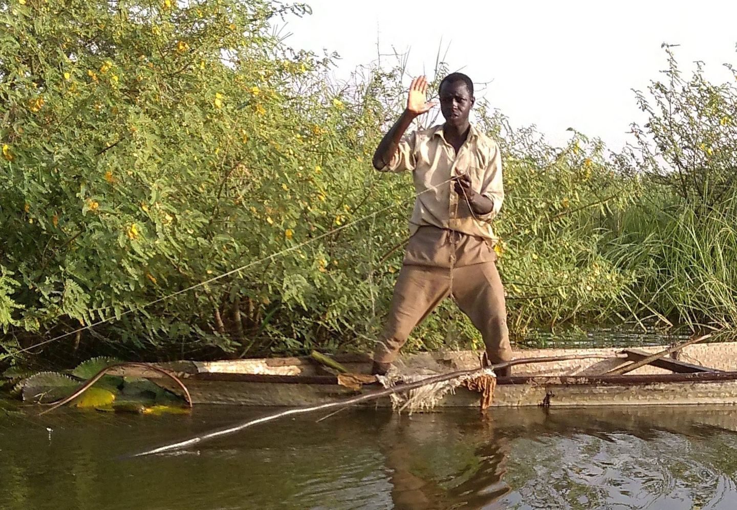 A fisherman waving from his boat on Lake Chad